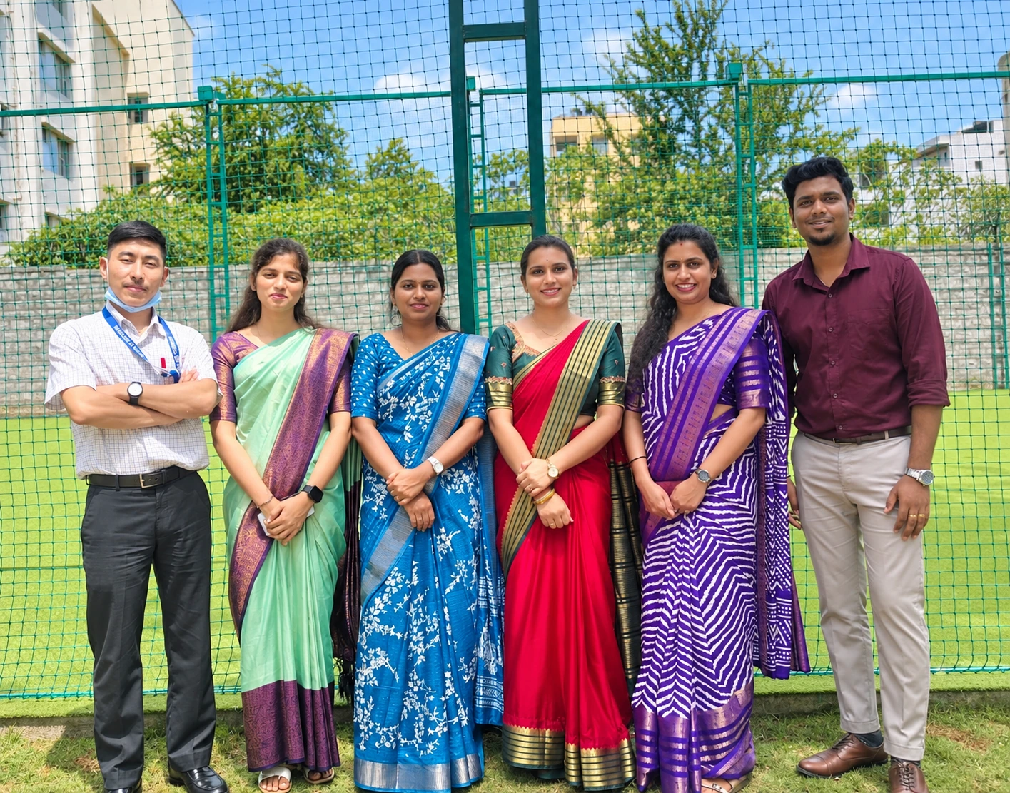 Members of the MVJ community pictured beside a sports enclosure